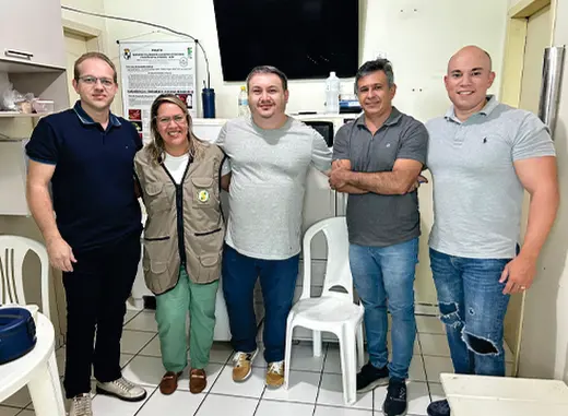 Cinco pessoas posam juntas em uma sala