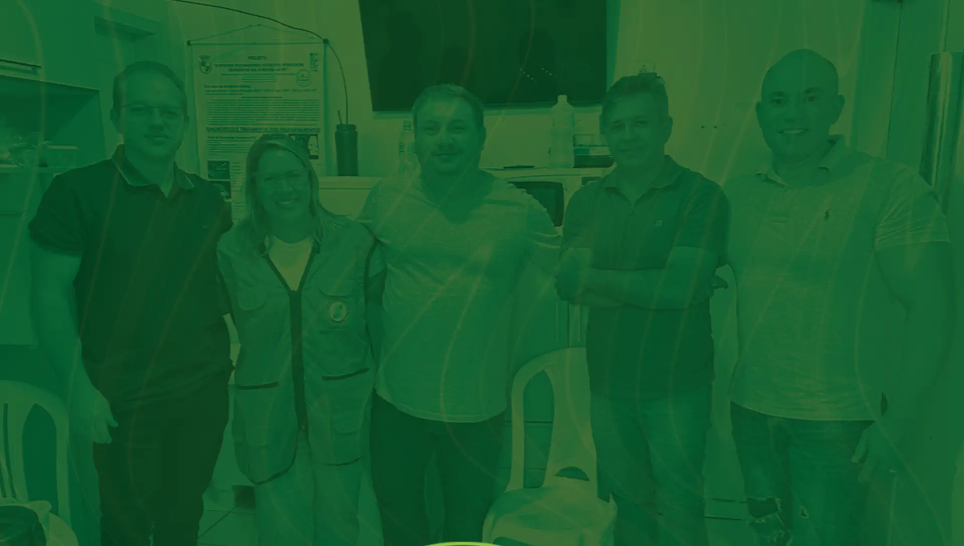 Cinco pessoas reunidas em uma sala, em foto com tratamento verde